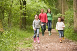 Family walking on path holding hands smiling